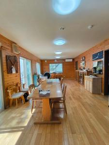 a dining room with a wooden table and chairs at 山の湯 in Wada