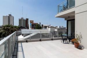 a balcony with a table and chairs on a building at Departamento Las Lomitas in Lomas de Zamora