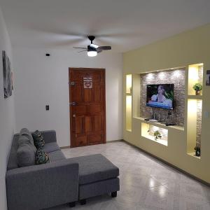 a living room with a couch and a tv at Departamento Familiar Escorpións in Tuxtla Gutiérrez