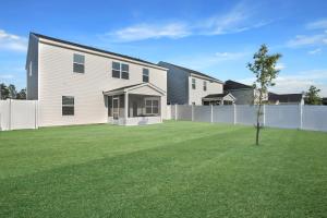 a white house with a yard with a fence at The Beautiful 31 in Port Wentworth