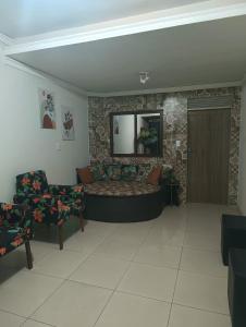 a living room with a couch and a mirror at Eds pousada in Juazeiro do Norte