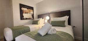 um quarto de hotel com duas camas com verde e branco em Absolute Collins Apartments em Melbourne