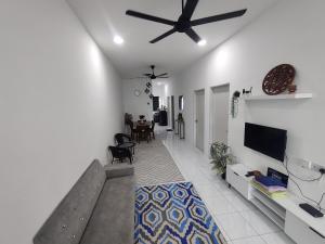a living room with a ceiling fan and a tv at Zh homestay teluk batik in Lumut