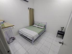 a small bedroom with a bed in a white room at Zh homestay teluk batik in Lumut