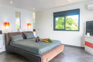 een slaapkamer met een bed met een teddybeer erop bij Villa Mont Sofa - Salle de jeux - Piscine & Jacuzzi - 5chb -10 pers in Sainte-Rose +58 foto's