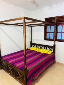 a wooden bed with a wooden frame in a room at Ranathunga Guest House in Ginimellagaha West