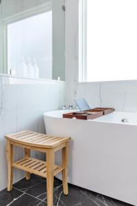 a bathroom with a bench and a tub and a table at The Beautiful 31 in Port Wentworth