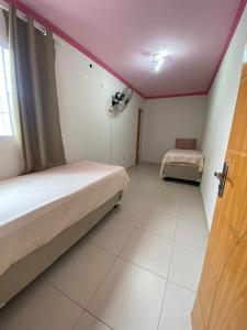 a small room with two beds and a window at Eds pousada in Juazeiro do Norte