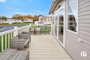 een terras met banken en tafels op een huis bij Vacant Nests The Gullane Seton Sands in Port Seton
