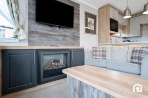 een woonkamer met open haard en een bank bij Vacant Nests The Gullane Seton Sands in Port Seton