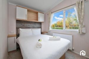 een slaapkamer met een groot wit bed en een raam bij Vacant Nests The Gullane Seton Sands in Port Seton