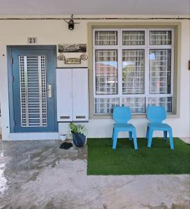 two blue chairs sitting in front of a house at Homestay BAYT AL - JAZMY in Kuantan