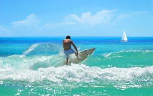a man riding a wave on a surfboard in the ocean at 140 Ocean Estates Dr in Lakewood Park