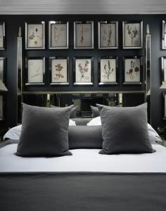 a bedroom with a bed and a wall with framed pictures at The Franklin London - Starhotels Collezione in London