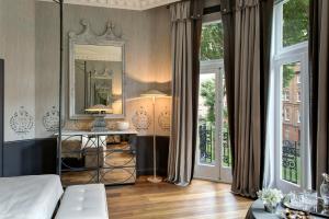 a bedroom with a bed and a mirror and windows at The Franklin London - Starhotels Collezione in London