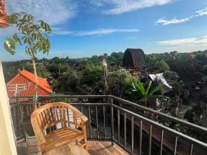 a balcony with a bench and a view at Kenari Diwang in Ubud