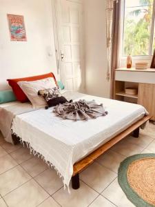 une chambre avec un lit avec des draps blancs dans l'établissement Ti Swell Caribbean House, à Port-Louis