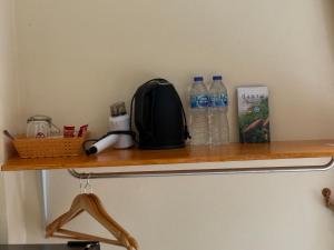 a shelf with a backpack and water bottles on it at Goodtimeบึงโขงหลง in Ban Don Klang