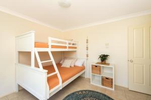 Un dormitorio con una litera y una escalera. en Walk to the Beach in Central Location, en Mollymook