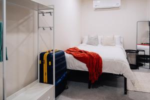 a bedroom with a bed and a suitcase at Desierto de Acero Containers in San José del Cabo
