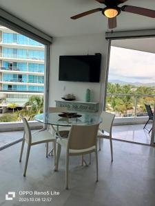 une salle à manger avec une table et des chaises et une télévision dans l'établissement Condominios Acqua, Nuevo Vallarta, à Nuevo Vallarta