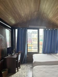 a bedroom with a bed and a desk and a window at Hanoi Hidden Guest House in Hanoi +20 photos