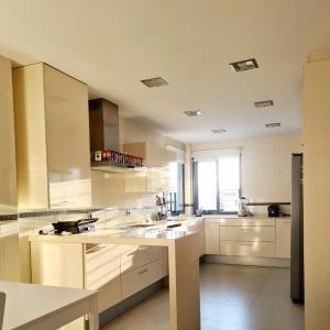 eine große Küche mit weißen Schränken und einem Fenster in der Unterkunft Chalet con Piscina de,3 hab in Dílar