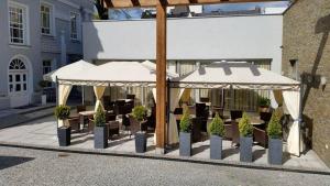 een groep tafels en stoelen onder parasols bij Hotel Willa Hueta in Kielce