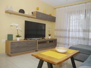 a living room with a television and a coffee table at Garden City in Playa Fañabe