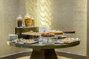 een buffet met diverse zoete deegwaren en desserts op een tafel bij Rosa Grand Milano - Starhotels Collezione in Milaan
