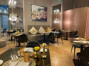 een restaurant met tafels, stoelen en kroonluchters bij Rosa Grand Milano - Starhotels Collezione in Milaan