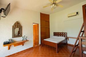 Un dormitorio con una cama y un espejo en la pared. en Large House with Pool in Yautepec, 4 Bedrooms, en Yautepec