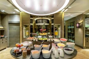 een buffet van eten op een tafel in een restaurant bij Rosa Grand Milano - Starhotels Collezione in Milaan +146 foto's