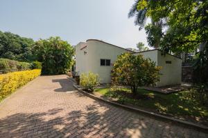 Un camino de ladrillo que conduce a una casa blanca con árboles en Large House with Pool in Yautepec, 4 Bedrooms, en Yautepec