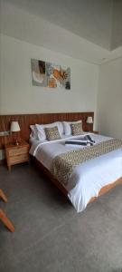 a bedroom with two beds and two lamps at La Reina villa in Ubud