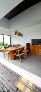 a living room with a wooden table and chairs at La Reina villa in Ubud +4 photos