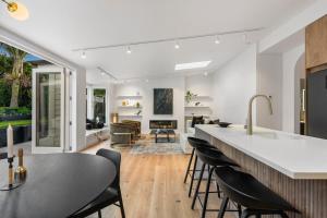 a kitchen and living room with a counter and chairs at Luxury Ponsonby Villa in Auckland