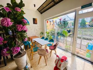 a dining room with a table and chairs and flowers at Dalat Peace Backpackers Hostel in Da Lat
