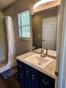 ein Badezimmer mit Waschbecken und großem Spiegel in der Unterkunft Quaint Cottage with Covered Dock on the Pond and Walking Trails in Georgia in Midway + 9 Fotos