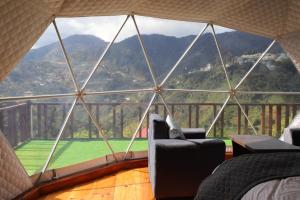 a room with a large glass window with a view at The kamcha Homestay in Bomdila