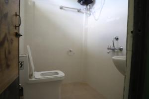 a white bathroom with a toilet and a sink at The kamcha Homestay in Bomdila
