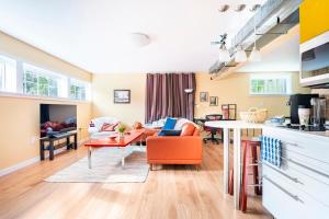 a living room with an orange chair and a table at Fresh Space Quiet Air Studio in Mercer Island