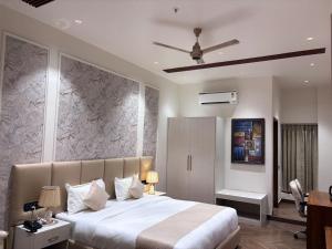 a bedroom with a large bed and a ceiling fan at B Dot in Gaushala