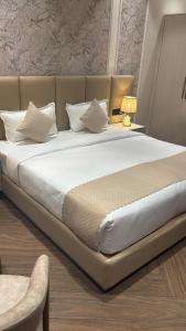 a large bed with white sheets and pillows at B Dot in Gaushala +10 photos