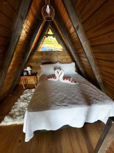 a bedroom with a bed in a log cabin at A-Frame da Lagoa in Imaruí