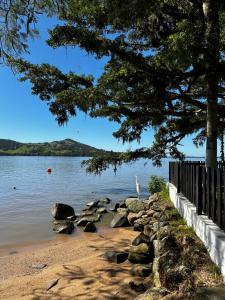 a white bird standing on the shore of a lake at A-Frame da Lagoa in Imaruí