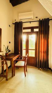 a dining room with a wooden table and a window at Brown Birds Villa in Tangalle