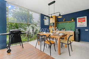une cuisine avec une table et des chaises en bois et des murs bleus dans l'établissement Marjara Villa by Kozystay - Dago, à Ciburial