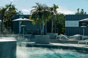 a swimming pool with a fountain and palm trees at BOTANICAL POOL CLUB in Kyonan +102 photos