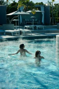 two women are swimming in a swimming pool at BOTANICAL POOL CLUB in Kyonan